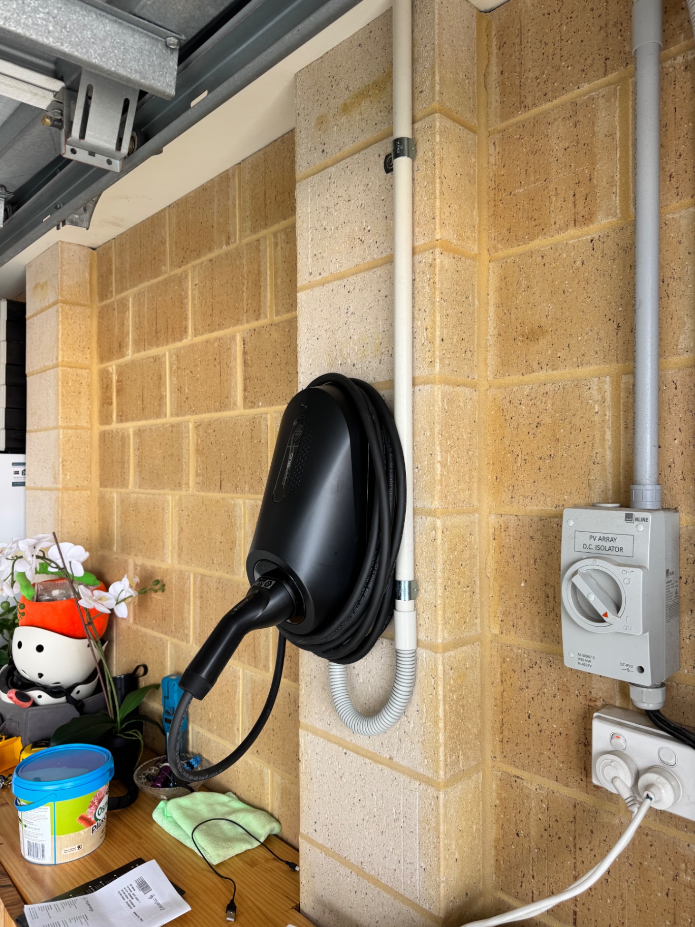 Black charger in a garage, neat conduit and solar isolator