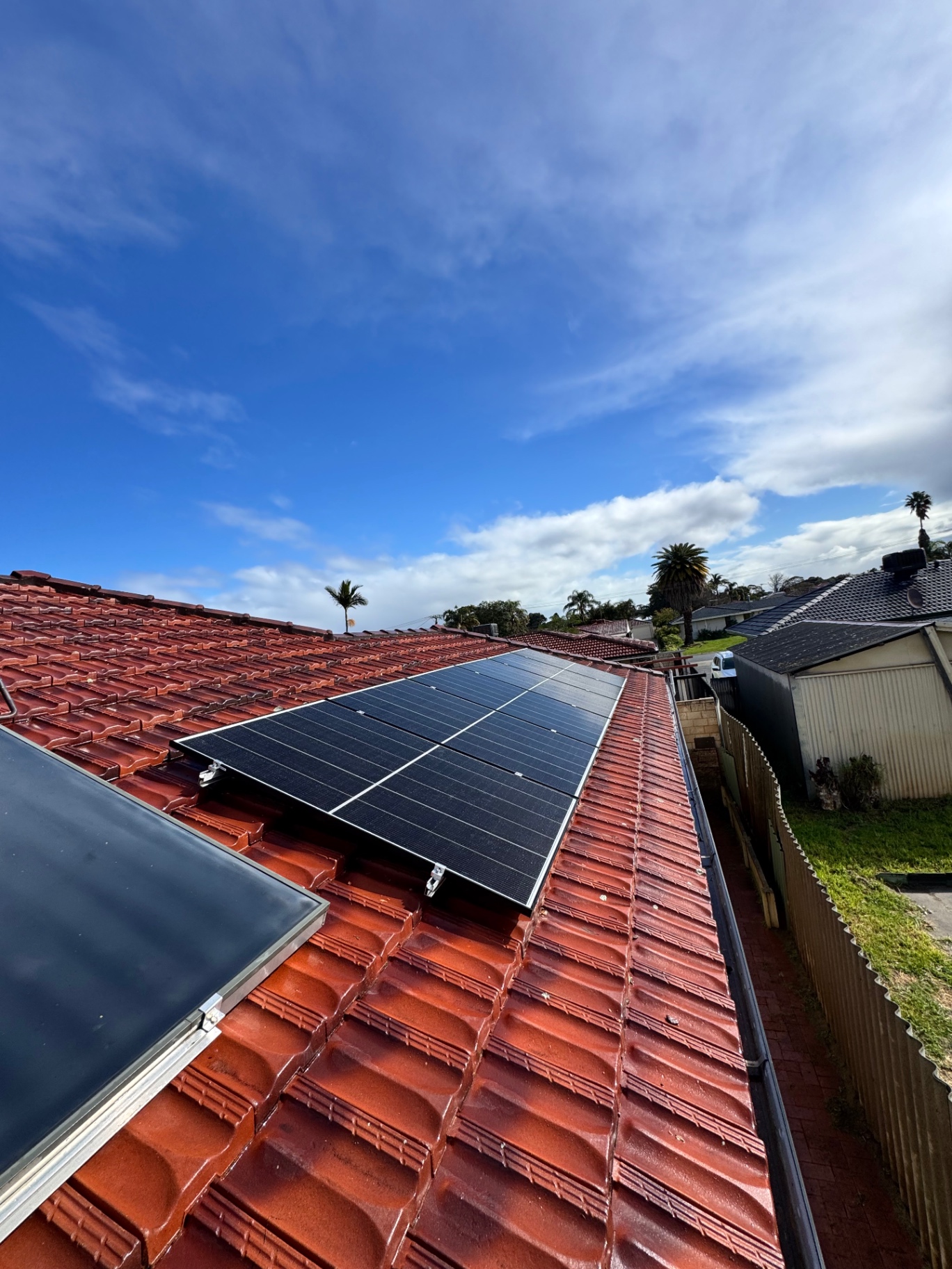 Closer view of Jinko panels on a red tile roof in Beechboro