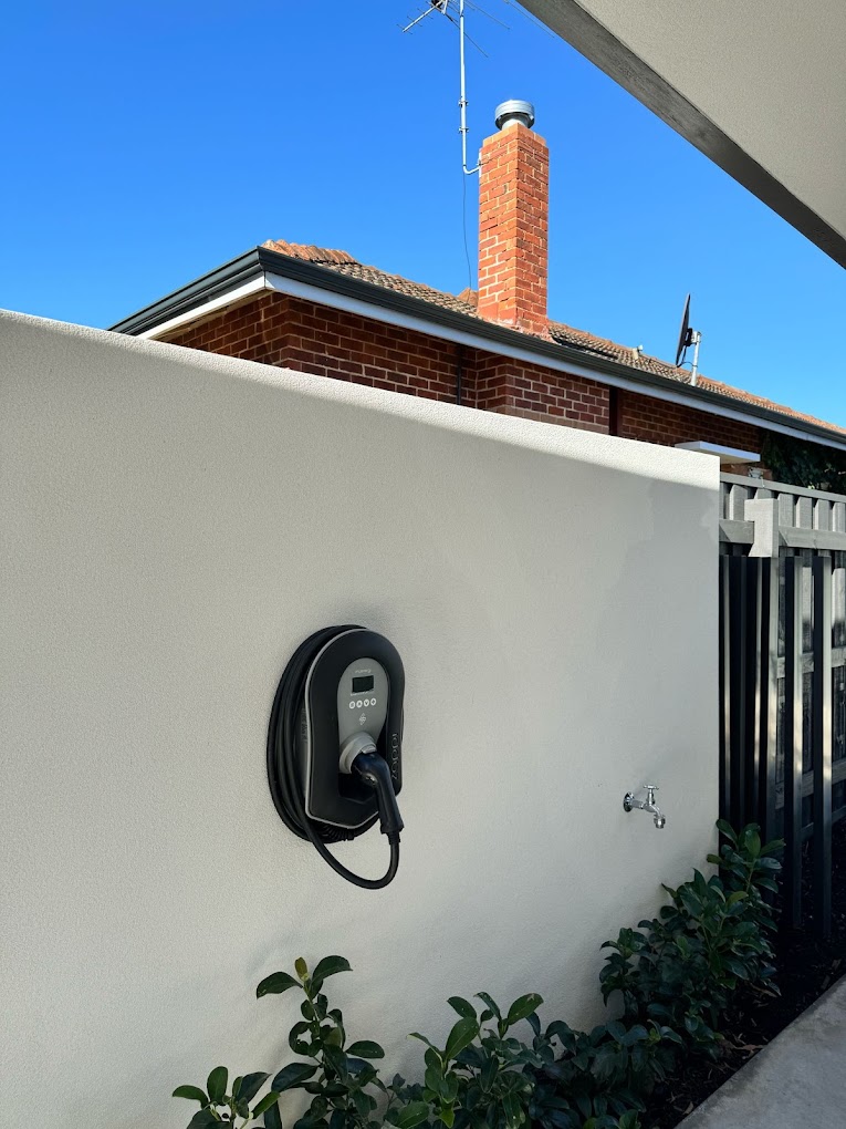 Tethered charger on rendered wall